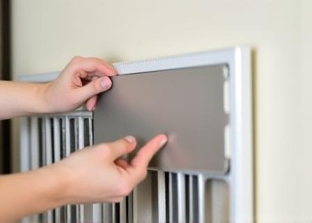 Installazione di un foglio riflettente in alluminio dietro un radiatore bianco